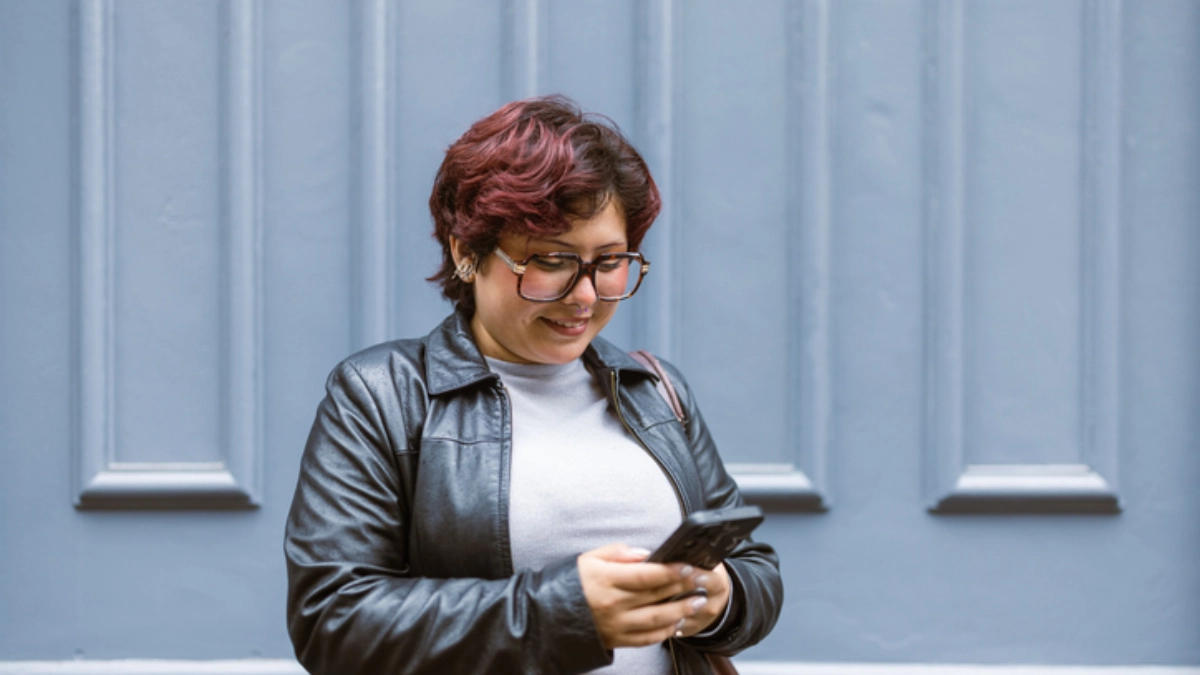 an image of a woman checking her phone outside