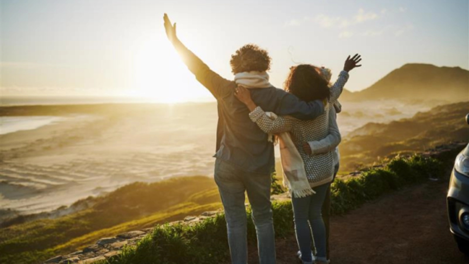 Two people enjoying a coastal sunset view