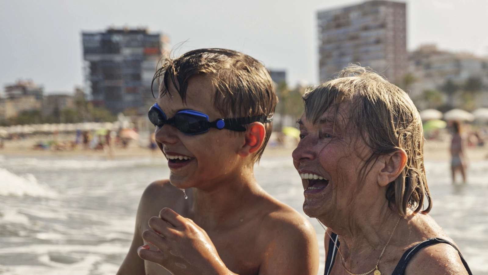 Grandmother and grandson holding hands on the beach